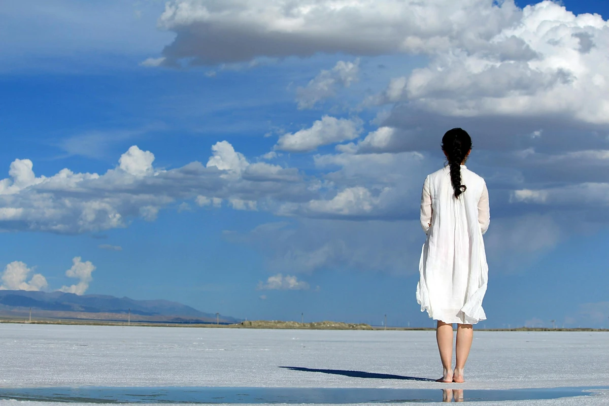Woman on beach, sand, blue sky